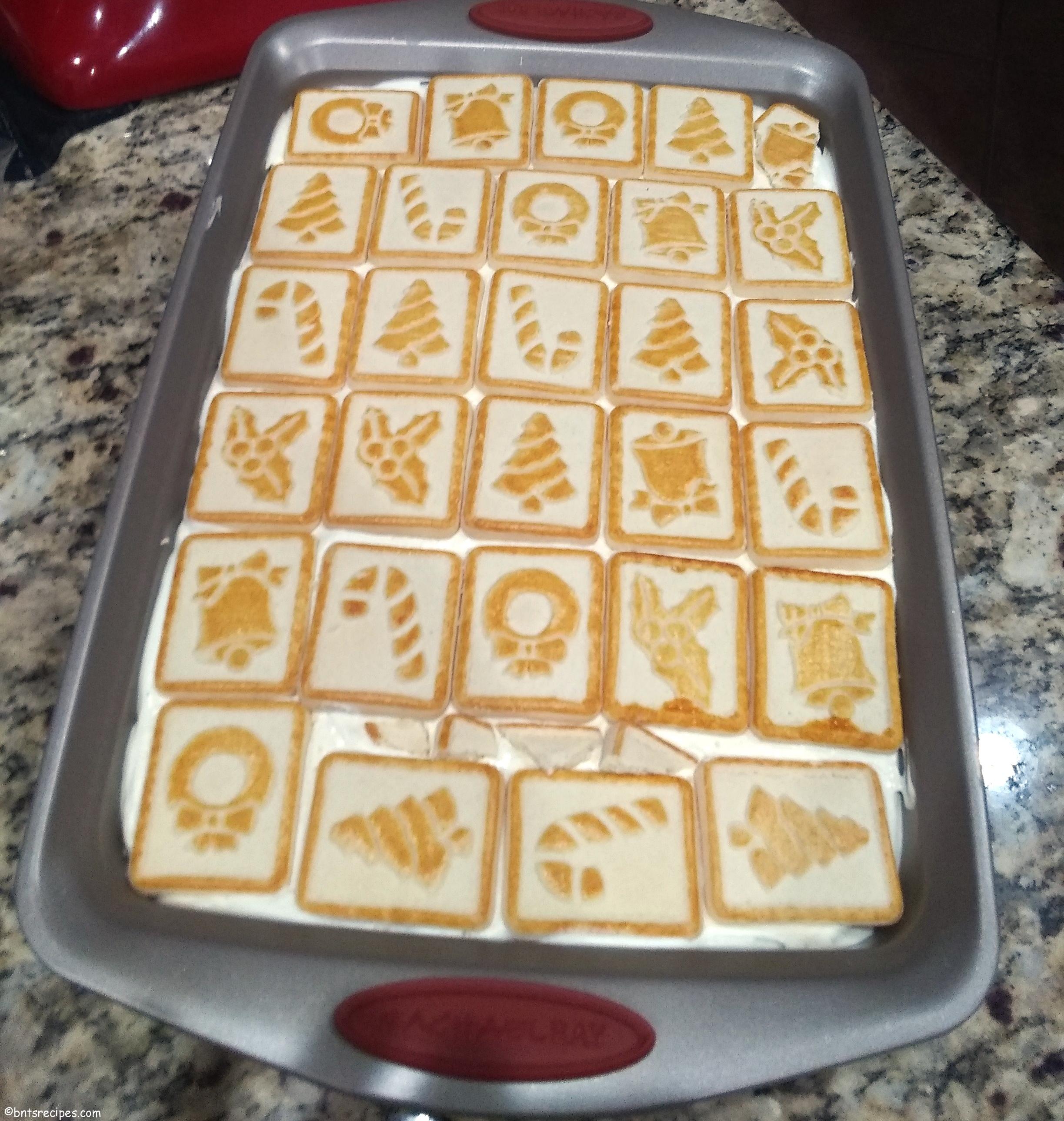 chessmen cookies banana pudding in a baking dish on top of a granite countertop