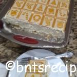 chessmen cookies banana pudding in a baking dish and sliced on a white plate with a fork on top of a granite countertop