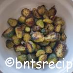 roasted brussels sprouts with a little char on them in a cream colored bowl