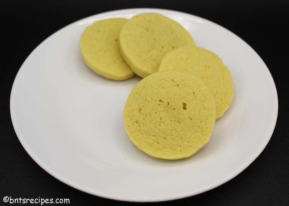lemon pudding slice and bake cookies on a white plate with black background