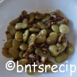 close-up of sauteed and braised lima beans with bacon bits