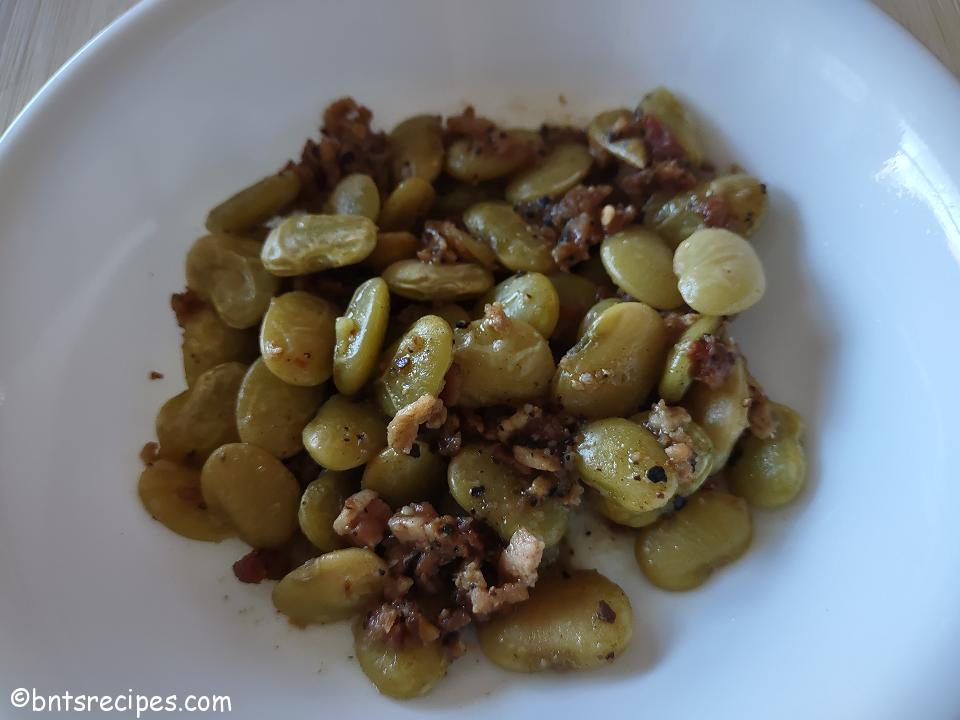 close-up of sauteed and braised lima beans with bacon bits