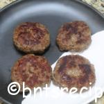 aerial view of cooked breakfast sausage patties on black white abstract bamboo plate