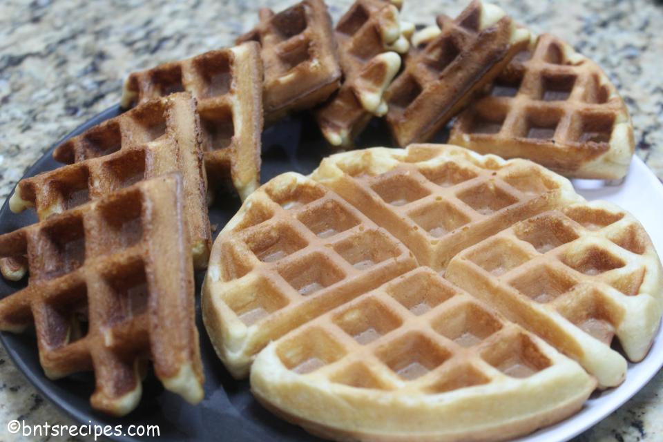 close-up view of fluffy buttermilk waffles on black and white abstract bamboo plate