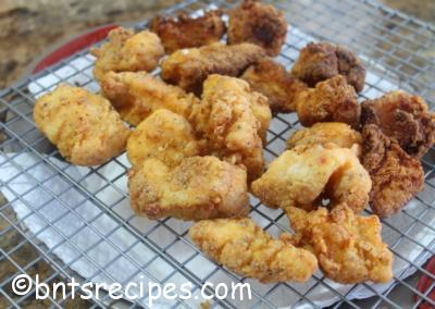 aerial view of crispy dark and golden brown pan fried cod nuggets on wire rack