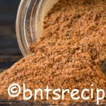 stock photo of jamaican jerk seasoning spilling from mason jar on wood surface